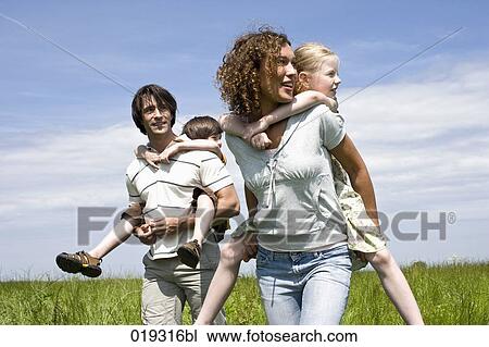 young parents giving their children piggyback ride View Large Photo Image Stock Image - young parents giving their children piggyback ride. Fotosearch