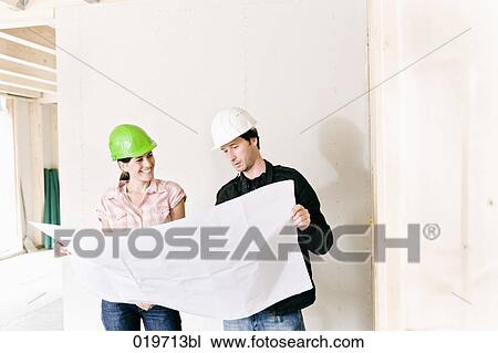young woman and architect looking at building plan View Large Photo Image Stock Image - young woman and architect looking at building plan. Fotosearch