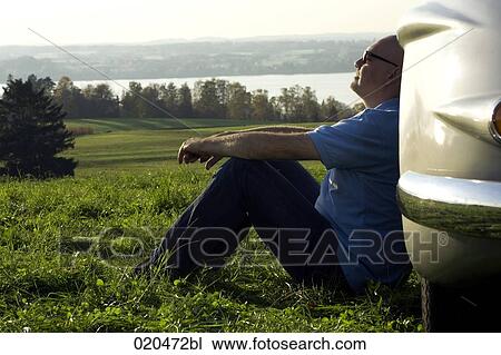 bald man sitting on meadow by his classic car View Large Photo Image Stock Image - bald man sitting on meadow by his classic car. Fotosearch