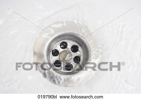 Stock Image - close-up of water running through drain. Fotosearch