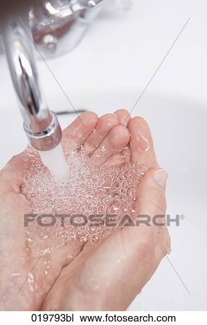 Stock Image - close-up of woman catching water in her hands. Fotosearch