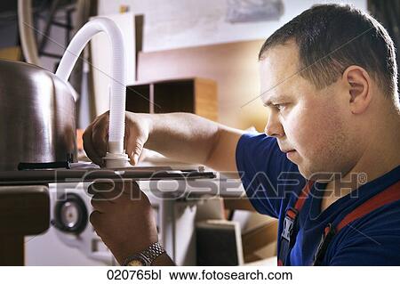 Stock Image - craftsman assembling kitchen sink. Fotosearch