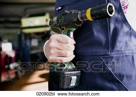 detail of female mechanic holding cordless wrench View Large Photo Image Stock Image - detail of female mechanic holding cordless wrench. Fotosearch