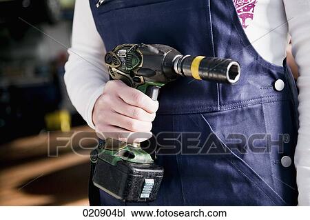 detail of female mechanic holding cordless wrench View Large Photo Image Stock Image - detail of female mechanic holding cordless wrench. Fotosearch