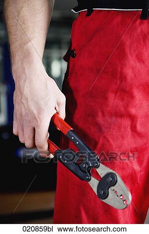 Stock Image - detail of mechanic holding tongs. Fotosearch