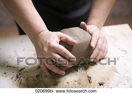 Stock Image - detail of potter forming piece of clay. Fotosearch