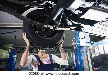 female mechanic changing tire on car View Large Photo Image Stock Image - female mechanic changing tire on car. Fotosearch
