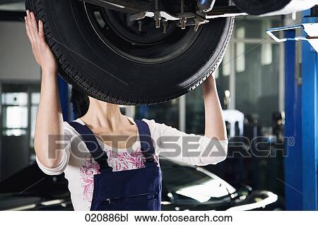 female mechanic changing tire on car View Large Photo Image Stock Image - female mechanic changing tire on car. Fotosearch