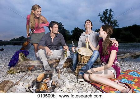 group of friends enjoying beer and sausages at party on riverbank in summer View Large Photo Image Stock Image - group of friends enjoying beer and sausages at party on riverbank in summer. Fotosearch