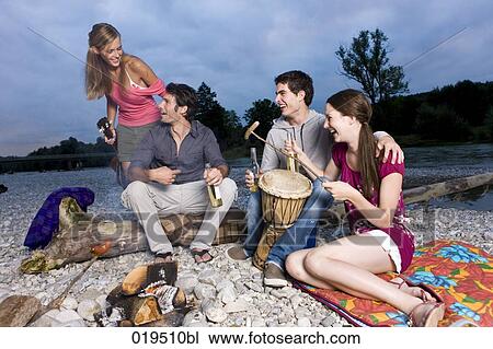 group of friends enjoying beer and sausages at party on riverbank in summer View Large Photo Image Stock Image - group of friends enjoying beer and sausages at party on riverbank in summer. Fotosearch