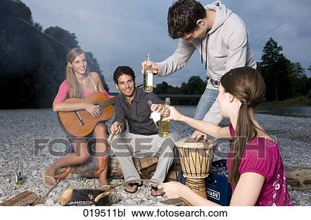 group of friends enjoying beer and sausages at party on riverbank in summer View Large Photo Image Stock Image - group of friends enjoying beer and sausages at party on riverbank in summer. Fotosearch