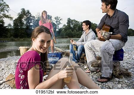 group of friends enjoying beer and sausages at party on riverbank in summer View Large Photo Image Stock Image - group of friends enjoying beer and sausages at party on riverbank in summer. Fotosearch