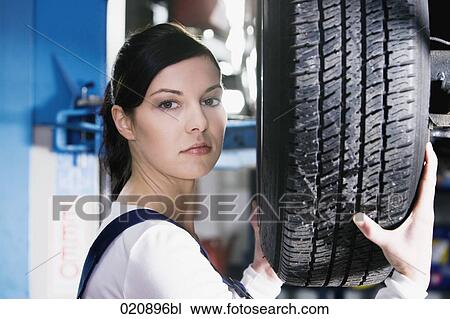 headshot of female mechanic changing tire on car View Large Photo Image Stock Image - headshot of female mechanic changing tire on car. Fotosearch