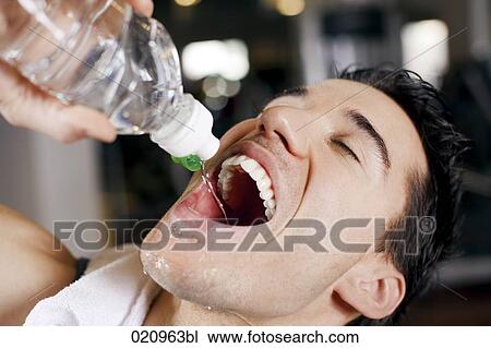 headshot of young man drinking water from bottle in gym View Large Photo Image Stock Image - headshot of young man drinking water from bottle in gym. Fotosearch
