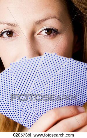 headshot of young woman hiding behind playing cards View Large Photo Image Stock Image - headshot of young woman hiding behind playing cards . Fotosearch