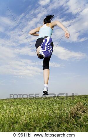 low angle view of young woman jogging through park View Large Photo Image Stock Image - low angle view of young woman jogging through park. Fotosearch