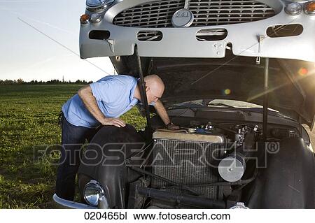 man repairing his classic car on empty road View Large Photo Image Stock Image - man repairing his classic car on empty road. Fotosearch