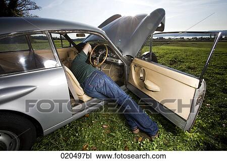 man repairing his classic car on meadow View Large Photo Image Stock Image - man repairing his classic car on meadow. Fotosearch