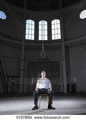 man sitting in empty hall looking at rope above him View Large Photo Image Stock Image - man sitting in empty hall looking at rope above him. Fotosearch