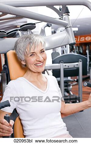 mature woman exercising on weight machine in gym View Large Photo Image Stock Image - mature woman exercising on weight machine in gym. Fotosearch