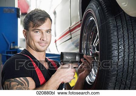 mechanic changing tire on car View Large Photo Image Stock Image - mechanic changing tire on car. Fotosearch