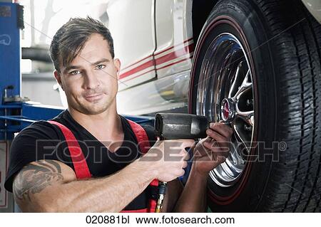mechanic changing tire on car View Large Photo Image Stock Image - mechanic changing tire on car. Fotosearch