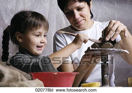 mother and daughter forming sculpture out of clay together View Large Photo Image Stock Image - mother and daughter forming sculpture out of clay together. Fotosearch