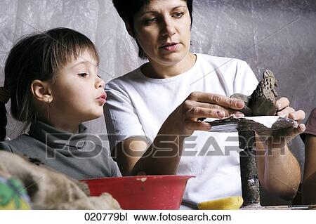 mother and daughter forming sculpture out of clay together View Large Photo Image Stock Image - mother and daughter forming sculpture out of clay together. Fotosearch