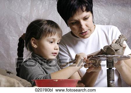 mother and daughter forming sculpture out of clay together View Large Photo Image Stock Image - mother and daughter forming sculpture out of clay together. Fotosearch