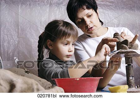 mother and daughter forming sculpture out of clay together View Large Photo Image Stock Image - mother and daughter forming sculpture out of clay together. Fotosearch