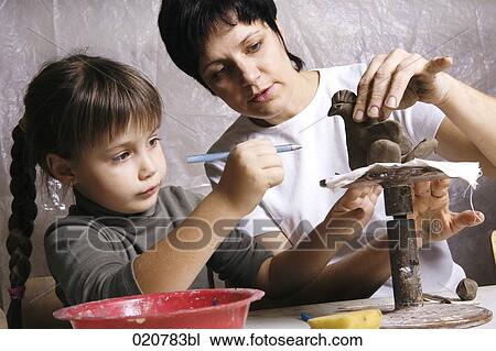 mother and daughter forming sculpture out of clay together View Large Photo Image Stock Image - mother and daughter forming sculpture out of clay together. Fotosearch