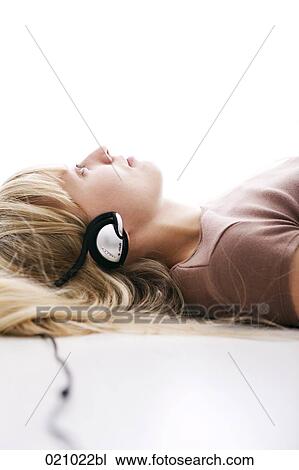portrait blond woman lying on floor waering headphones listening to music View Large Photo Image Stock Image - portrait blond woman lying on floor waering headphones listening to music . Fotosearch