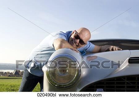 portrait of bald man leaning happily on his classic car View Large Photo Image Stock Image - portrait of bald man leaning happily on his classic car. Fotosearch