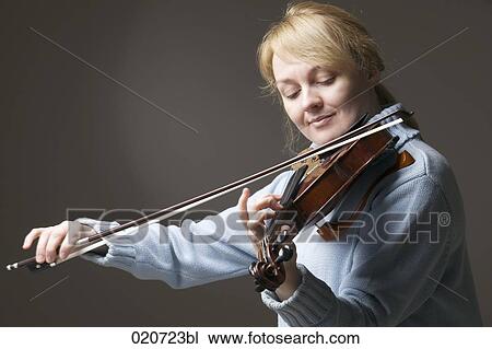 Stock Image - portrait of blond woman playing violin. Fotosearch