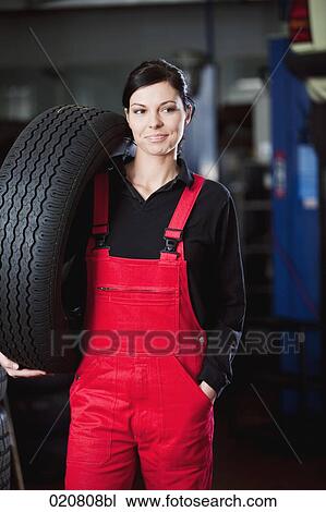portrait of female mechanic carrying tire View Large Photo Image Stock Image - portrait of female mechanic carrying tire. Fotosearch