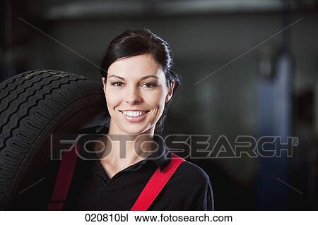 portrait of female mechanic carrying tire View Large Photo Image Stock Image - portrait of female mechanic carrying tire. Fotosearch