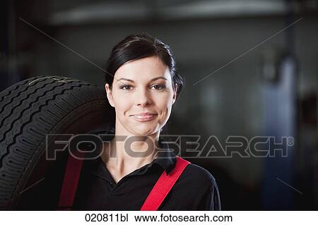 portrait of female mechanic carrying tire View Large Photo Image Stock Image - portrait of female mechanic carrying tire. Fotosearch