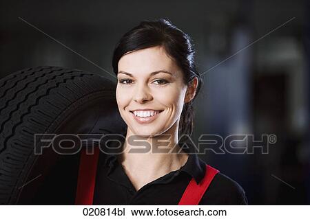 portrait of female mechanic carrying tire View Large Photo Image Stock Image - portrait of female mechanic carrying tire. Fotosearch