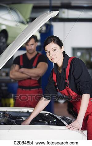 portrait of female mechanic repairing car with male colleague watching View Large Photo Image Stock Image - portrait of female mechanic repairing car with male colleague watching. Fotosearch