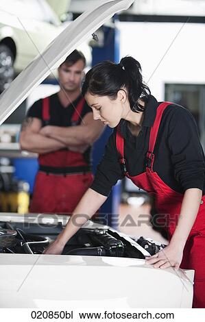 portrait of female mechanic repairing car with male colleague watching View Large Photo Image Stock Image - portrait of female mechanic repairing car with male colleague watching. Fotosearch
