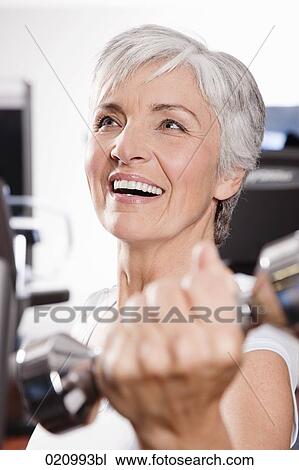 portrait of mature woman exercising with dumb bells View Large Photo Image Stock Image - portrait of mature woman exercising with dumb bells. Fotosearch