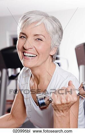 portrait of mature woman exercising with dumb bells View Large Photo Image Stock Image - portrait of mature woman exercising with dumb bells. Fotosearch