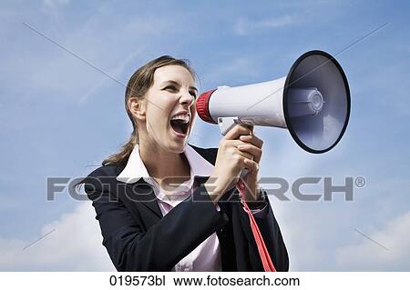 Stock Image - portrait of young businesswoman shouting through megaphone. Fotosearch