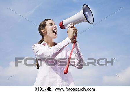 Stock Image - portrait of young businesswoman shouting through megaphone. Fotosearch