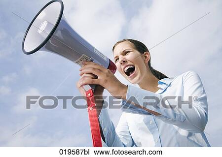 Stock Image - portrait of young businesswoman shouting through megaphone. Fotosearch
