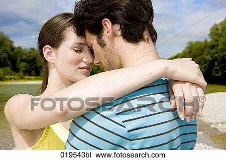 Stock Image - portrait of young couple in tender embrace outdoors. Fotosearch