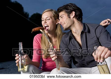 portrait of young couple sharing sausage at party on riverbank in summer View Large Photo Image Stock Image - portrait of young couple sharing sausage at party on riverbank in summer. Fotosearch