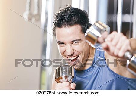 portrait of young man exercising with dumb bells View Large Photo Image Stock Image - portrait of young man exercising with dumb bells. Fotosearch