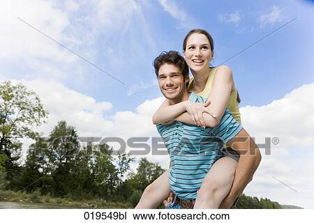 portrait of young man giving girlfriend piggyback ride View Large Photo Image Stock Image - portrait of young man giving girlfriend piggyback ride. Fotosearch