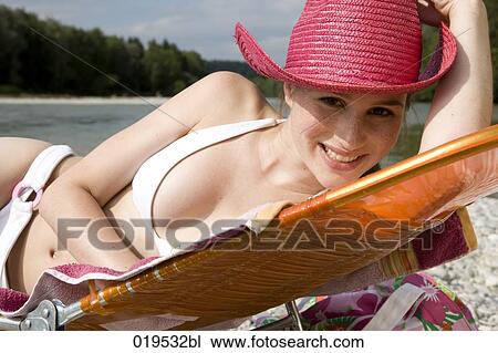 portrait of young woman taking sunbath by river View Large Photo Image Stock Image - portrait of young woman taking sunbath by river. Fotosearch